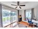 Bedroom with sliding glass doors to balcony, hardwood floors, and home office space at 2937 Bough Ave # D, Clearwater, FL 33760