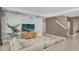 Spacious living room with a large sectional sofa and a statement wall at 30684 Penny Surf Loop, Wesley Chapel, FL 33545