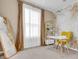 Dedicated home office with a yellow chair, a white desk and a gold accent shelf at 30684 Penny Surf Loop, Wesley Chapel, FL 33545