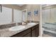Shared bathroom with double sinks, dark brown cabinets, and a shower/tub combo at 30684 Penny Surf Loop, Wesley Chapel, FL 33545