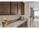 Modern kitchen features dark brown cabinets, granite countertops, and a view into the dining area at 30684 Penny Surf Loop, Wesley Chapel, FL 33545