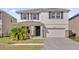 Charming two-story home featuring stone accents, a welcoming front door, and a well-manicured lawn at 30684 Penny Surf Loop, Wesley Chapel, FL 33545