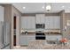 Modern kitchen with gray cabinets, granite countertops and stainless steel appliances at 30684 Penny Surf Loop, Wesley Chapel, FL 33545