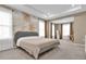 Bright and airy main bedroom with a neutral color palette and tropical-themed wall art at 30684 Penny Surf Loop, Wesley Chapel, FL 33545