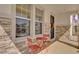 Inviting front porch with stone facade and red metal bistro set at 30684 Penny Surf Loop, Wesley Chapel, FL 33545