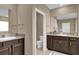 Double vanity bathroom with dark brown cabinets and granite countertop at 30684 Penny Surf Loop, Wesley Chapel, FL 33545