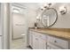 Bathroom with granite countertop, white cabinets, and a large round mirror at 165 Lakeview Way # 165, Oldsmar, FL 34677