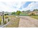 Single-story house with green exterior, palm trees, and a paved driveway at 2010 E Del Webb Blvd, Sun City Center, FL 33573