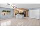 Open floor plan featuring tile flooring, a ceiling fan, and a breakfast bar adjoining the kitchen at 8019 Cedar Run Dr, Port Richey, FL 34668