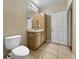 Bathroom with a wooden vanity, linen closet, tiled floor, and a toilet at 10108 Courtney Oaks Cir # 203, Tampa, FL 33619