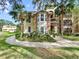 Attractive condominium exterior with stone accents, bay window, and mature landscaping with palm trees at 10108 Courtney Oaks Cir # 203, Tampa, FL 33619