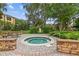 Hot tub surrounded by lush landscaping and a brick paver patio at 10108 Courtney Oaks Cir # 203, Tampa, FL 33619