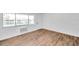 Living room with large window, wood-look floors, and AC unit at 2353 Shelley St # 16, Clearwater, FL 33765