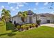 One-story home with two-car garage and lush tropical landscaping at 5085 Ivory Stone Dr, Wimauma, FL 33598