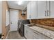 Laundry room with modern washer, dryer, and granite countertop at 531 Isleworth Close, Tarpon Springs, FL 34688