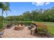 Brick fire pit with seating area and scenic backyard view at 531 Isleworth Close, Tarpon Springs, FL 34688