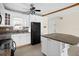 Well-lit kitchen featuring white cabinets, granite countertops, tile flooring, and modern black appliances at 7625 Sun Island S Dr # 101, South Pasadena, FL 33707