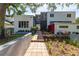Modern two-story home with gray and white exterior, landscaped walkway, and lush greenery at 838 Monterey Ne Blvd, St Petersburg, FL 33704