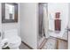 Clean bathroom with a toilet, shower, and patterned rug at 838 Monterey Ne Blvd, St Petersburg, FL 33704