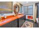 Bright bathroom boasts an orange countertop, dark cabinets, and a large mirror at 838 Monterey Ne Blvd, St Petersburg, FL 33704