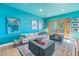 Bright living room with teal walls, comfy seating, and access to a patio at 838 Monterey Ne Blvd, St Petersburg, FL 33704