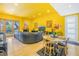 Modern living room with yellow walls, black leather sofa, and hardwood floors at 838 Monterey Ne Blvd, St Petersburg, FL 33704