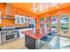 Bright kitchen with orange walls, stainless steel appliances, and breakfast bar at 838 Monterey Ne Blvd, St Petersburg, FL 33704