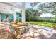 Outdoor patio with wood dining table, chairs, and lush landscaping at 838 Monterey Ne Blvd, St Petersburg, FL 33704