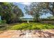 Spacious backyard with grassy lawn, mature trees, and waterfront views at 838 Monterey Ne Blvd, St Petersburg, FL 33704