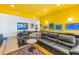 Bright living room with yellow walls, leather sectional sofa, and modern coffee table at 838 Monterey Ne Blvd, St Petersburg, FL 33704