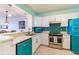 Updated kitchen with teal accents and stainless steel appliances at 16500 Gulf Blvd # 352, North Redington Beach, FL 33708