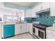 Modern kitchen with teal appliances and mosaic backsplash at 16500 Gulf Blvd # 352, North Redington Beach, FL 33708