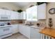 Efficient kitchen with white cabinets and a corner sink with views to backyard at 24617 Laurel Ridge Dr, Lutz, FL 33559