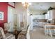 Bright kitchen with white cabinets, a glass-top table for four and access to the living room at 24617 Laurel Ridge Dr, Lutz, FL 33559