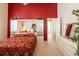 Bedroom with built-in mirrored wardrobe and red bedding at 24617 Laurel Ridge Dr, Lutz, FL 33559