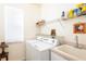 Laundry room with washer, dryer, and storage shelves at 24617 Laurel Ridge Dr, Lutz, FL 33559