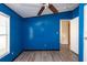 Bedroom with blue walls, ceiling fan, and wood-look flooring at 38029 Leondias Dr, Zephyrhills, FL 33542