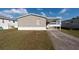 Tan single wide mobile home with carport at 38029 Leondias Dr, Zephyrhills, FL 33542