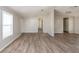 Open living room with wood-look floors and hallway at 38029 Leondias Dr, Zephyrhills, FL 33542