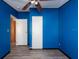Bright bedroom with blue walls, ceiling fan, and wood-look flooring at 38029 Leondias Dr, Zephyrhills, FL 33542