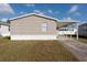 Tan single wide mobile home with carport at 38029 Leondias Dr, Zephyrhills, FL 33542