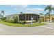 Mobile home with covered porch, landscaped yard, and screened patio at 18675 Us Highway 19 N # 488, Clearwater, FL 33764