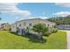 Well-maintained manufactured home with landscaping and AC unit at 18675 Us Highway 19 N # 488, Clearwater, FL 33764