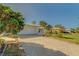 Front view of a single story home with a white garage door and landscaping at 2043 Imperial Way, Clearwater, FL 33764