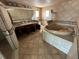 Bathroom featuring a corner soaking tub, tiled walls, and a dual sink vanity at 239 Punta Vista Dr, St Pete Beach, FL 33706