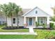 Charming one-story house with light gray siding, teal door, and landscaped yard at 4077 Broad Porch Run, Land O Lakes, FL 34638