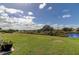 Spacious backyard with pond and lush green grass at 5220 Butterfly Shell Dr, Apollo Beach, FL 33572