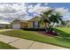 Tan house with palm trees and well-manicured lawn at 5220 Butterfly Shell Dr, Apollo Beach, FL 33572