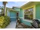 Front entrance with teal exterior, brick walkway, and potted plants at 5331 Jacaranda Ave, North Port, FL 34291