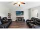 Living room with two black reclining sofas and a fireplace at 5369 Boxtree Ct, Dade City, FL 33523